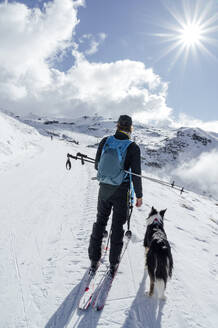 Mann stehend mit Hund an einem sonnigen Tag - PGF01475