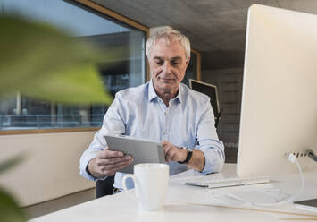 Älterer Geschäftsmann benutzt Tablet-PC im Büro - UUF28261