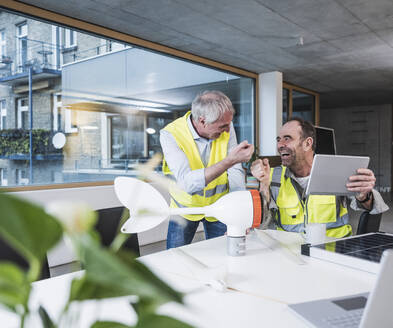 Ingenieur gibt einem Kollegen im Büro einen Faustschlag - UUF28292