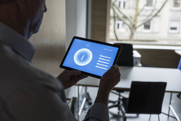 Businessman with tablet PC showing home automation app display at office - UUF28360