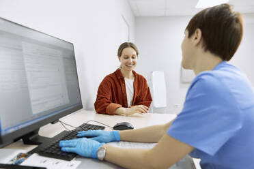 Lächelnder Patient im Gespräch mit dem Augenarzt in der Klinik - SANF00039