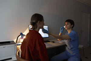 Ophthalmologist taking medical exam of patient at clinic - SANF00042