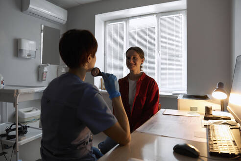 Ophthalmologist talking to patient at clinic - SANF00043