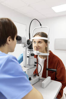 Augenarzt bei der Augenuntersuchung eines Patienten in der Klinik - SANF00045