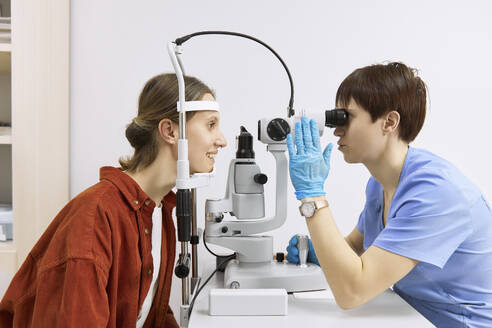 Augenarzt bei der Durchführung eines Sehtests mit einem Patienten in der Klinik - SANF00046