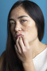 Woman with freckles in front of colored background - MRAF00919