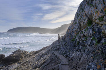 Südafrika, Ostkap, Männlicher Wanderer auf schmaler Küstenpromenade in Plettenberg Bay - LBF03775