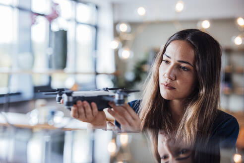 Junge Geschäftsfrau prüft Drohne im Büro - JOSEF17491