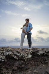 Woman leaning on boyfriend standing on mountain - FBAF02115