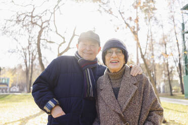 Smiling senior man with woman at autumn park - SEAF01752