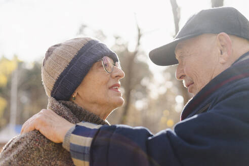 Älteres Paar in warmer Kleidung, das sich im Park miteinander unterhält - SEAF01763