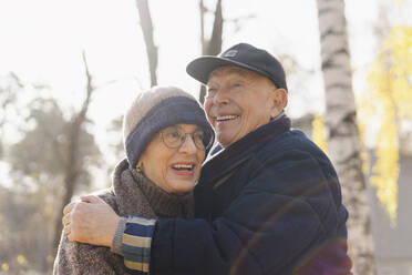 Happy elderly man embracing woman at park - SEAF01764