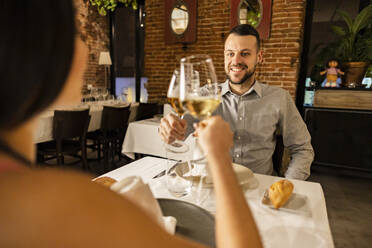 Ehepaar stößt mit Weingläsern im Restaurant an - JCCMF09591