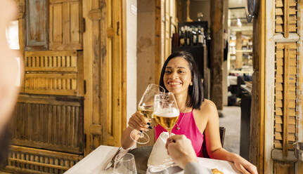 Glückliche Frau stößt mit ihrem Freund im Restaurant mit einem Weinglas an - JCCMF09593