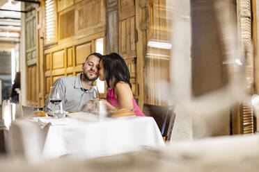 Zärtliches Paar berührt sich im Restaurant an der Stirn - JCCMF09608