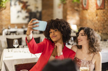 Lächelnde Freunde machen ein Selfie im Restaurant - JCCMF09623