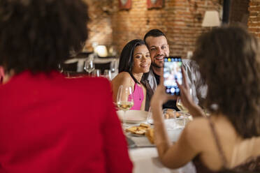 Frau macht Fotos von Freunden im Restaurant - JCCMF09637