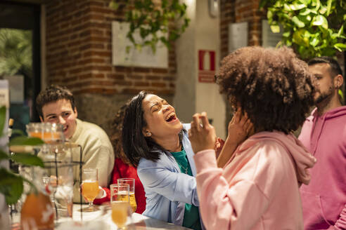 Glückliche Frau genießt mit Freunden im Restaurant - JCCMF09655