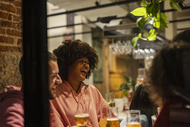 Glückliche Frau mit Afrofrisur genießt im Restaurant - JCCMF09660