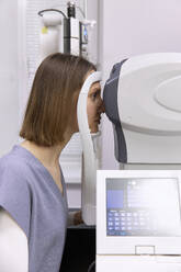 Young patient doing vision diagnostics test in clinic - SANF00064