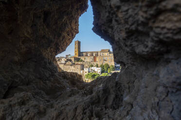 Italy, Lazio, Sutri, Cathedral of Santa Maria Assunta seen through hole in rock wall - MAMF02579