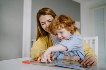 Mutter und Sohn lesen zu Hause ein Kinderbuch - MDOF00794