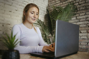 Businesswoman typing on laptop at office - RCPF01727