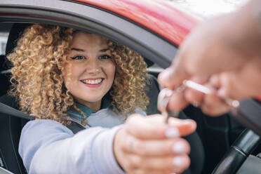 Happy woman giving car keys to personal valet - AMWF01176