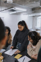 Young businesswoman discussing strategy with female colleagues while working in office - MASF35485