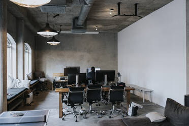 Rear view of male hacker working on computer in creative office - MASF35490