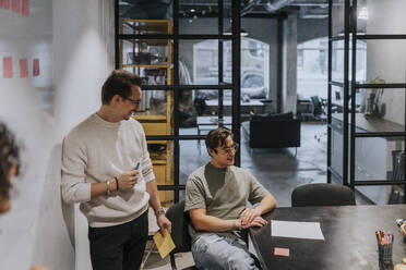 Smiling male entrepreneurs discussing in meeting at board room - MASF35536