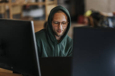 Männlicher Computerprogrammierer arbeitet an einem Laptop in einem kreativen Büro - MASF35567