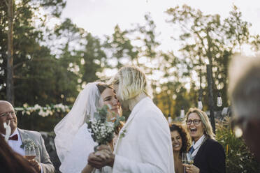 Glückliche Braut und Bräutigam tanzen zusammen inmitten der Gäste während der Hochzeitszeremonie - MASF35770