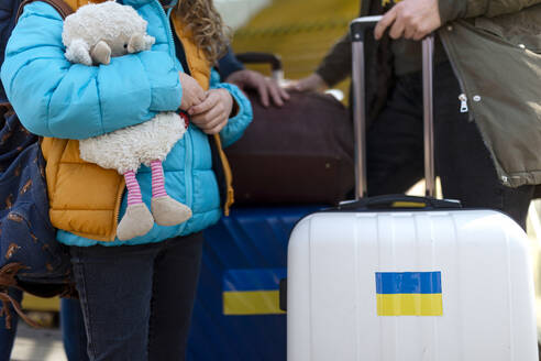 A close-up of Ukrainian immigrants with luggage waiting at train station, Ukrainian war concept. - HPIF07034