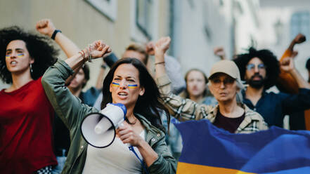 Eine Gruppe von Aktivisten, die gegen die russische Militärinvasion in der Ukraine protestieren, geht auf der Straße. - HPIF07054