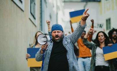 Eine Gruppe von Aktivisten, die gegen die russische Militärinvasion in der Ukraine protestieren, geht auf der Straße. - HPIF07055