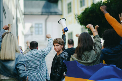 Eine Gruppe von Aktivisten, die gegen die russische Militärinvasion in der Ukraine protestieren, geht auf der Straße. - HPIF07056