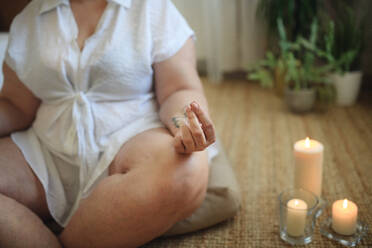 A close-up of overweight woman meditating at home. - HPIF07075