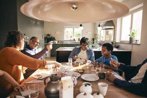 Eine Mehrgenerationen-Familie, die gemeinsam das Essen auf dem Esstisch zu Hause genießt - MASF36037