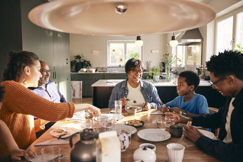 Eine gemischtrassige Familie genießt das gemeinsame Essen zu Hause - MASF36038