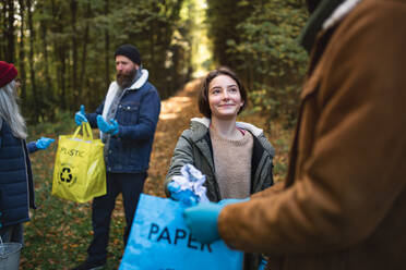 Eine bunt gemischte Gruppe von Freiwilligen säubert den Wald von Abfällen, Konzept der gemeinnützigen Arbeit - HPIF07114