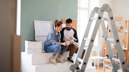 A mid adults couple with colour swatch indoors at home, relocation and diy concept. - HPIF07242