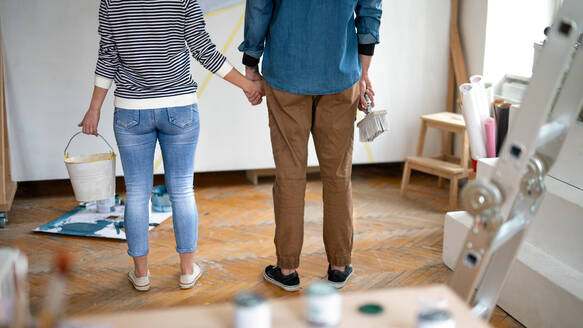 Unrecognizable mid adults couple painting wall indoors at home, relocation and diy concept. - HPIF07263