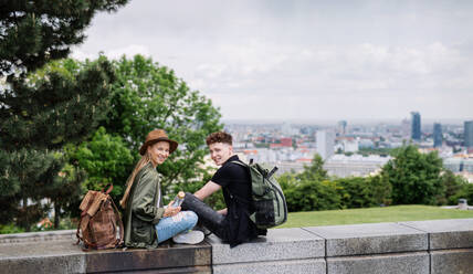 Porträt eines jungen Paares, das mit einem Stadtplan in den Urlaub fährt und in die Kamera schaut. - HPIF07291