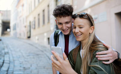 Junges Paar Reisende zu Fuß mit smarthone in der Stadt im Urlaub, Sightseeing. - HPIF07303