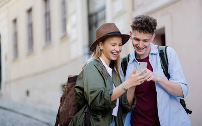 Junges Paar Reisende zu Fuß mit smarthone in der Stadt im Urlaub, Sightseeing. - HPIF07308