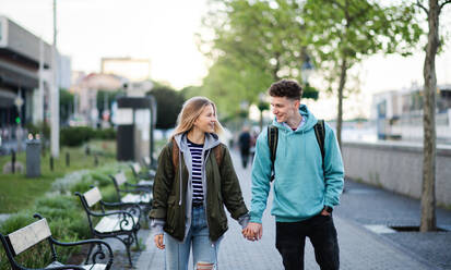 Ein glückliches junges Paar, das in der Stadt Urlaub macht, spazieren geht und sich unterhält. - HPIF07317