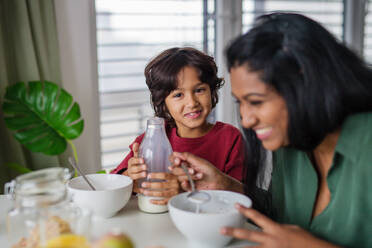 A little boy having breakfast with his mother at home. - HPIF07342