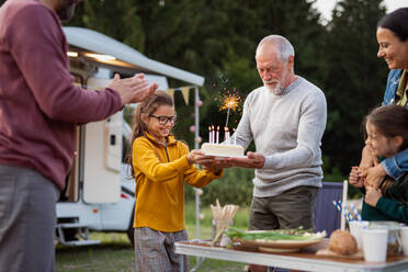 Eine Mehrgenerationen-Familie feiert ihren Geburtstag auf dem Campingplatz, Urlaub mit dem Wohnwagen. - HPIF07434