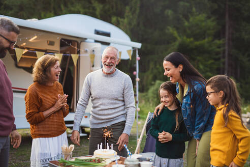 Eine Mehrgenerationen-Familie feiert ihren Geburtstag auf dem Campingplatz, Urlaub mit dem Wohnwagen. - HPIF07437